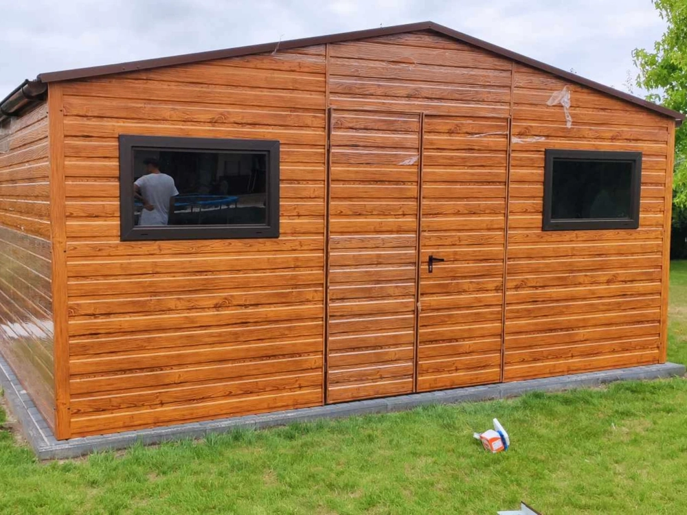 Domek narzędziowy ze stalowych paneli w drewnopodobnym wykończeniu, z dwiema poziomymi oknami i drzwiami