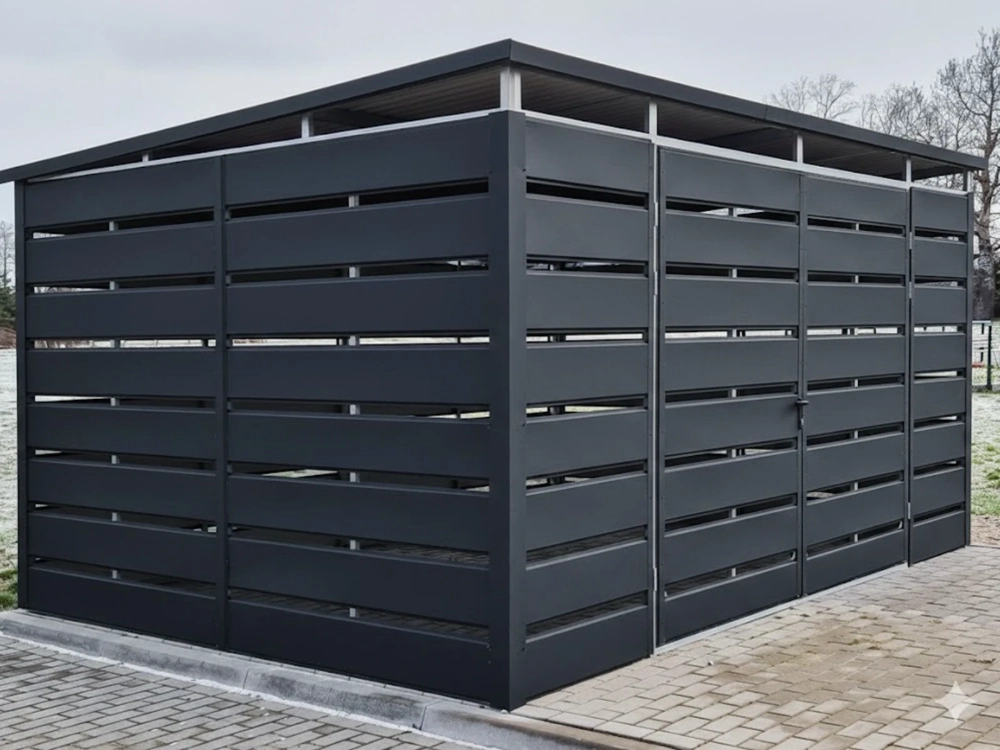 Wiata śmietnikowa ze stalowych paneli malowanych proszkowo na podjeździe z kostki brukowej