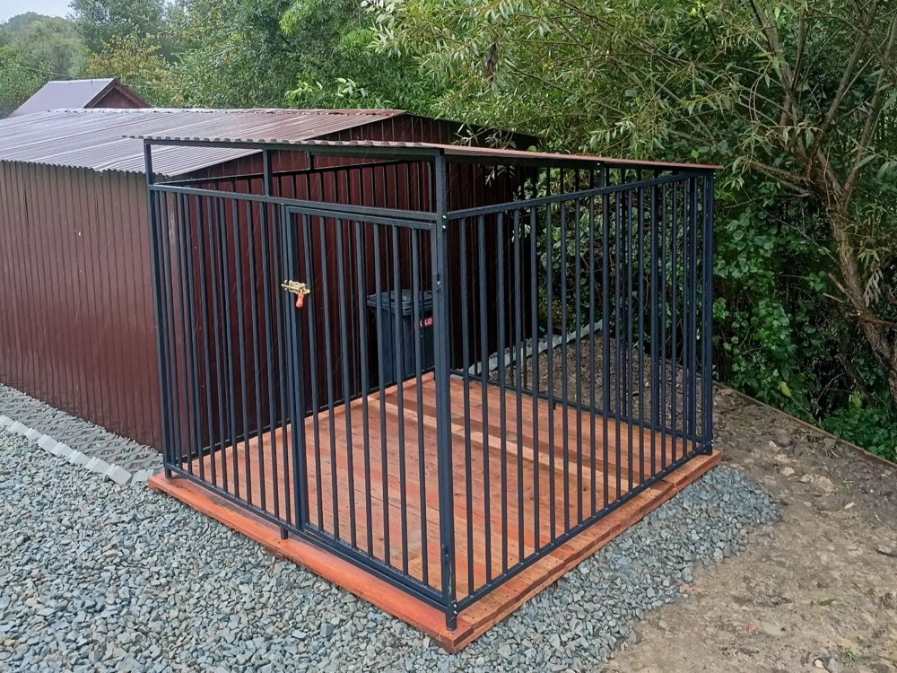 Stalowy kojec dla psa na drewnianej podłodze z zadaszeniem