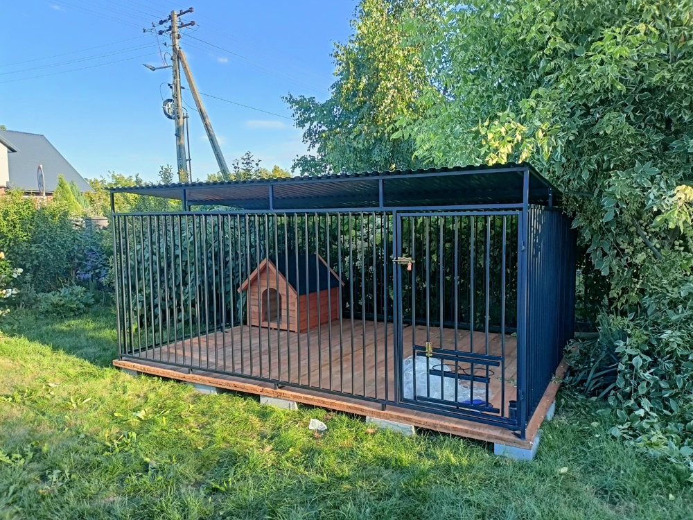 Stalowe kojce dla psów z drewnianą budą i zadaszeniem w ogrodzie